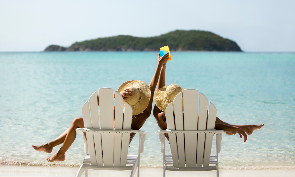 Two college students sitting in beach chairs, applying for scholarships, summer break scholarships, scholarships with July deadlines, scholarships due in August, upcoming scholarship deadlines