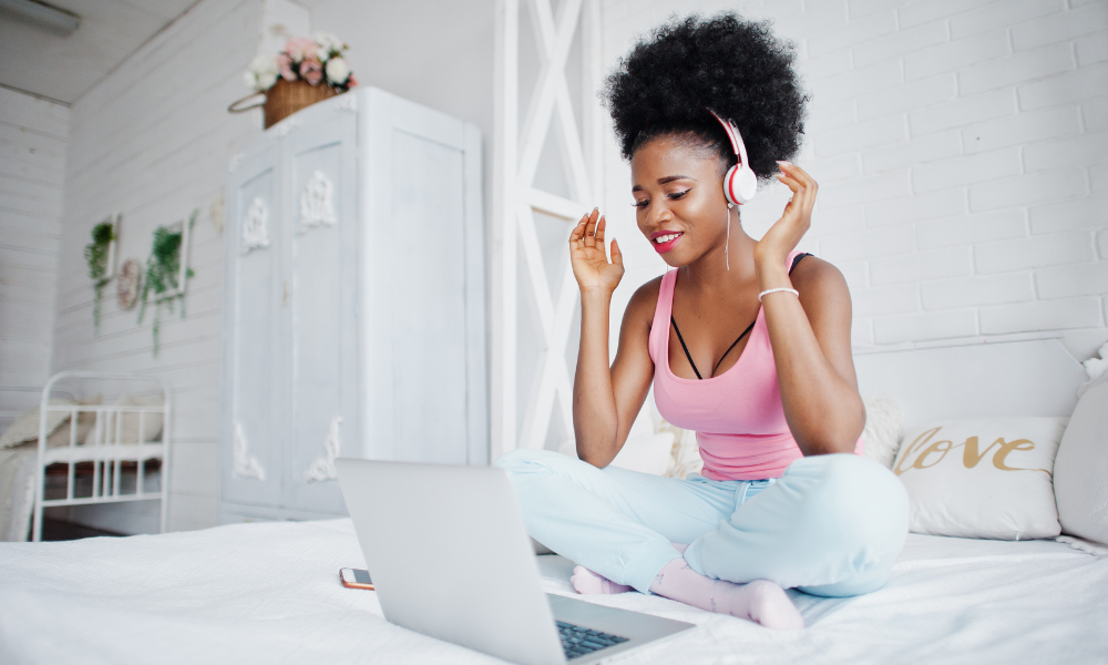 Make Easy and Quick Money from your College Campus, side gig, side hustle, part-time job, adaptable, flexible, on-campus, remote work, work from school, work from home, college student working from her dorm with headphones sitting on her bed in front of her laptop