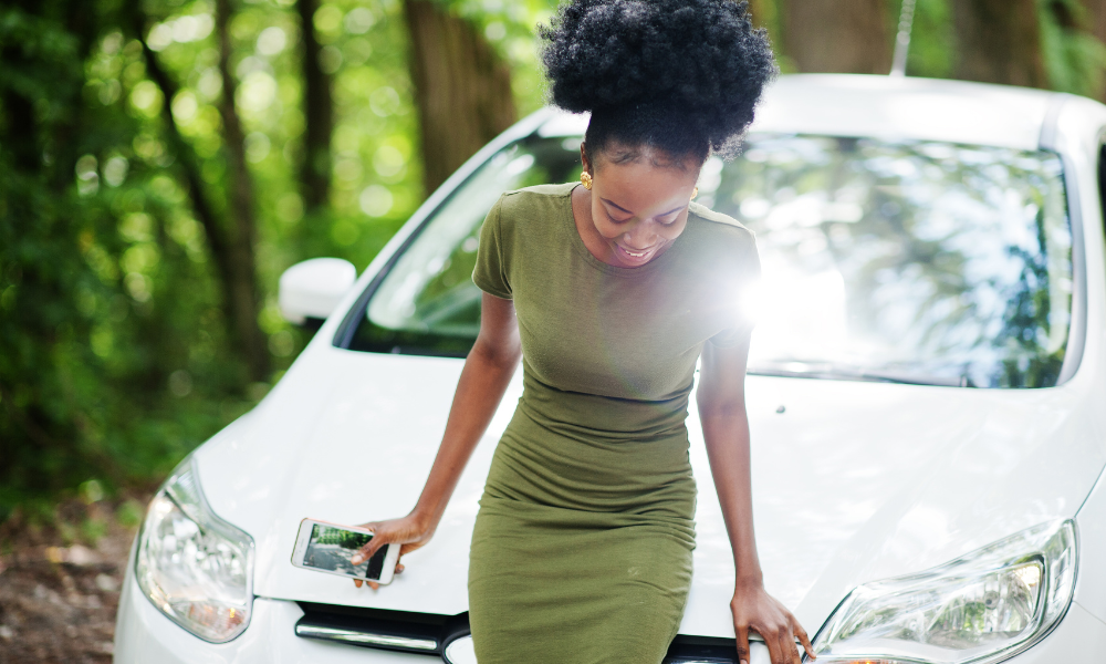 A recent grad standing in front of her car and getting ready to go on a girls' trip, car dealership, old car, auto loan, big purchase, credit cards, much money, new vehicle, tough time, oil changes, lots of money, first-time car buyers, total costs, fuel efficiency