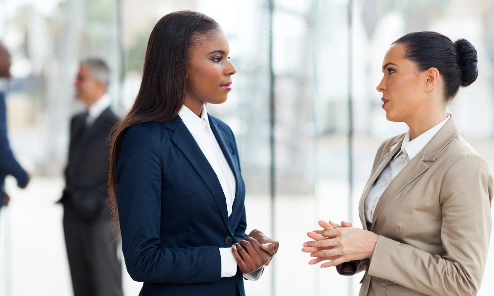 A summer college intern is speaking with her peer at their internship program, application deadlines, summer internships, internship opportunities, academic credit, hourly rate, graduate student, internship sites