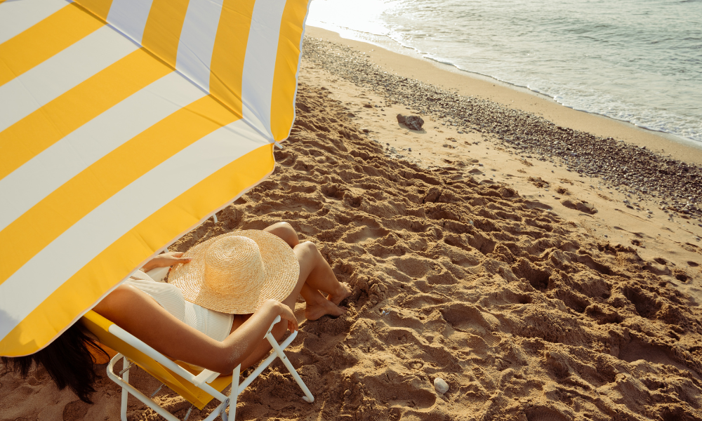 A high school student at the beach sitting under an umbrella, applying for July scholarships, higher education, scholarship program, college scholarships, federal student aid, accredited college, u,s, citizen, international student, community college, trade school, vocational school, certificate program, grad student, undergraduate, graduate student, law school, law student