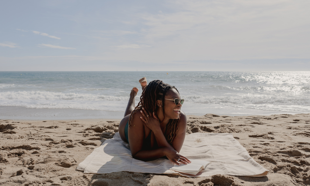 High school student laying on her beach towel with her scholarship spreadsheet, scholarships with upcoming deadlines, summer break scholarships, fall scholarships, money for college, african american students, black students, native american students, hispanic students, pacific island students
