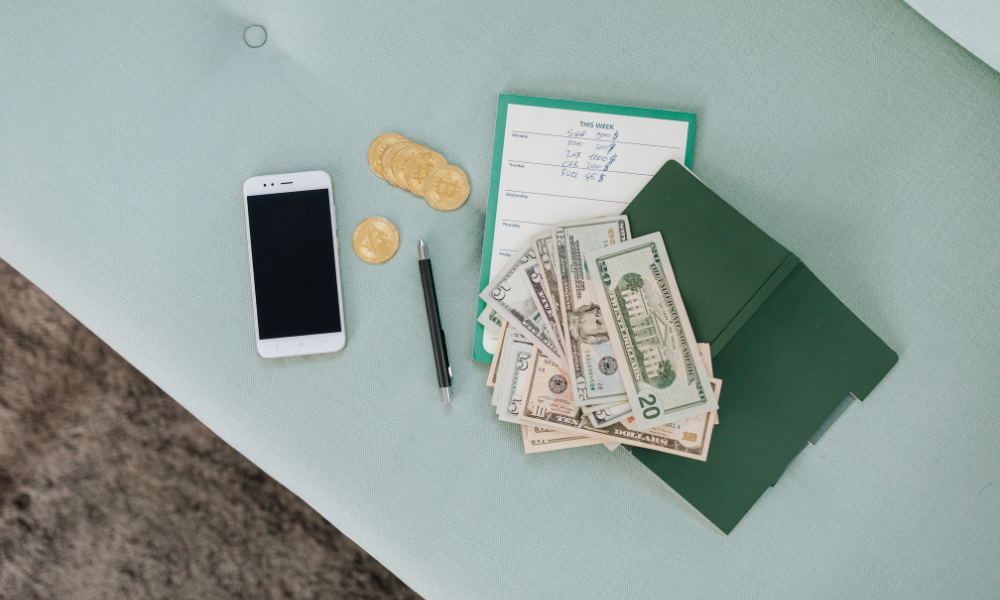 A graduate student has her notebook, tablet, phone, and scholarship money on her desk, she will continue to look for graduate scholarships with summer deadlines, scholarships for medical school, and easy and quick college scholarships