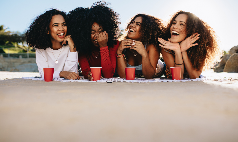 Girls on the beach talking about applying for the best August scholarships for current college students, for nursing majors, STEM majors, Engineering majors, Art majors, Finance majors, Business majors, Education majors