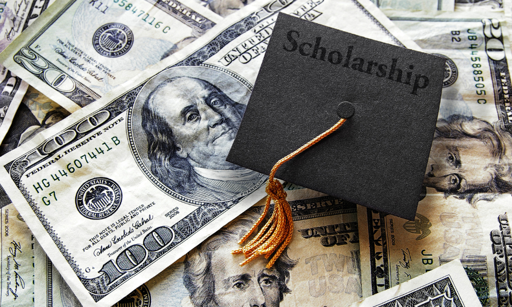 A graduation cap on top of a pile of college money, underrepresented students, graduate level, minority group, application process, nation's largest private scholarship provider, cbc spouses, engineering programs, student debt, military programs, support students, financial need, winter scholarships, November scholarship opportunities