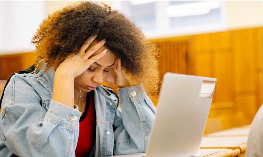 A high school student is in the library and is on her lap top checking for common scholarship mistakes.
