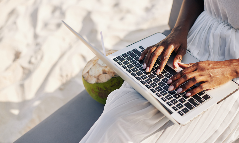 A second year law student is at the beach looking on her laptop for easy grad scholarships with summer deadlines. The graduate student is looking for law scholarships, merit scholarships, and community service scholarships