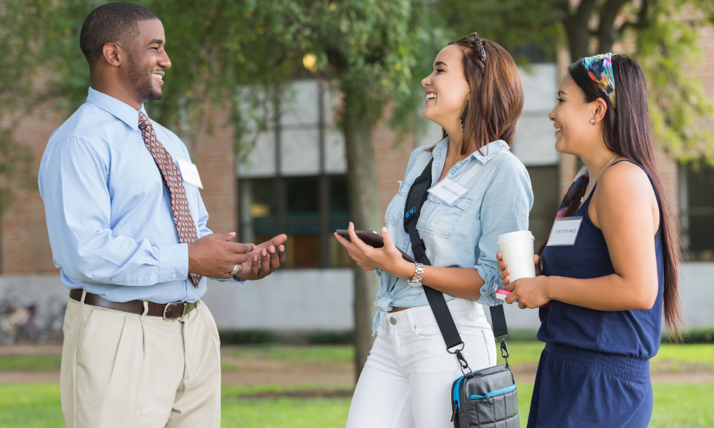 A high school senior and her mom are speaking with a college recruiter during the fly-in program. They have learned about the available financial aid, application fee waivers, and listened to a panel of alumni, professors, and current students. They plan to take advantage of the visit colleges for free programs