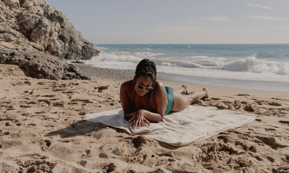 An HBCU student is at the beach completing scholarship opportunities from her summer scholarship list. These scholarships have June deadlines, July deadlines, August deadlines