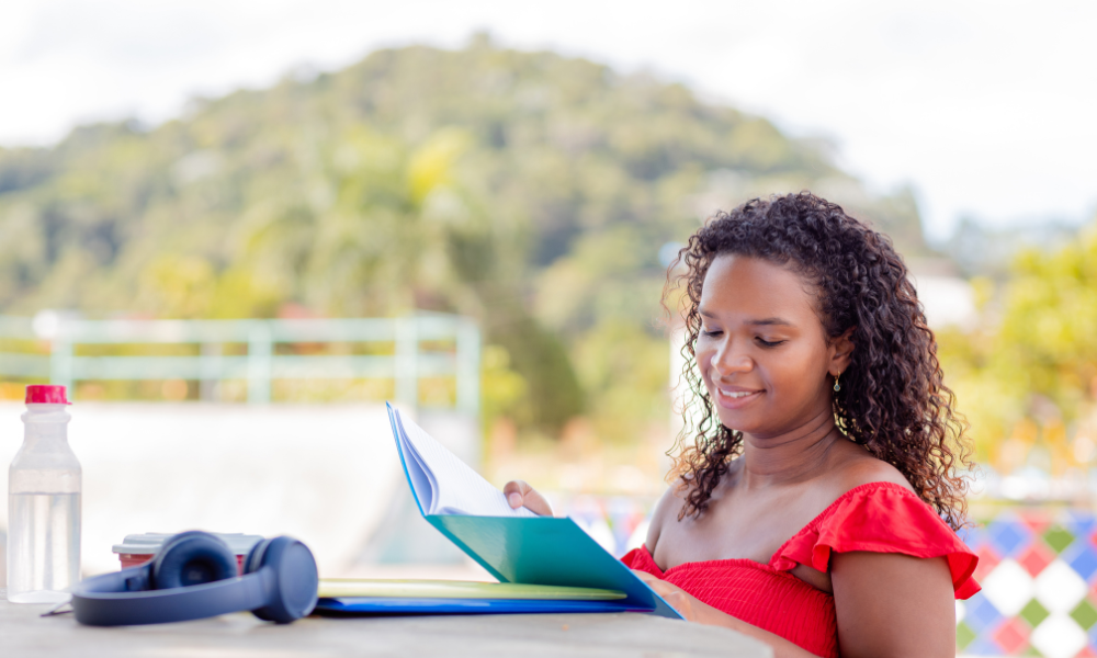Female student is spending her summer working and applying for scholarships to help reduce her student debt. She is looking for easy grad scholarships with summer deadlines, scholarships for African American students, and scholarships for black females