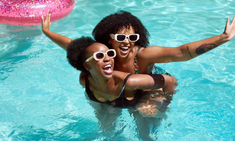 Two college students who are swimming in the pool and strategizing on how to whittle down their student debt. They plan on applying for minority scholarships, HBCU scholarships, and summer break scholarships for black college students
