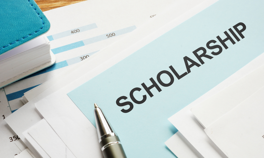 College bound student has a stack of scholarship applications. She is trying to win late summer scholarships, no-essay scholarships, full-ride scholarships, and local scholarships