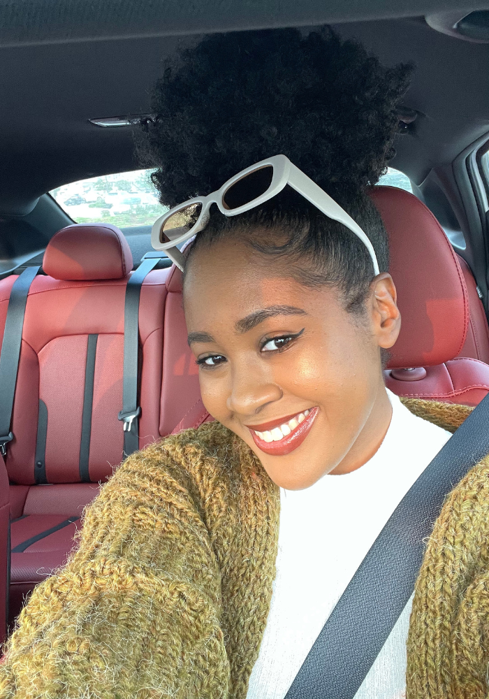 Twentysomething female sitting in her car smiling, best option, first time, best deal, credit score, kelley blue book, kind of car, good shape, car price, hard time, good idea, disposable income, used vehicle