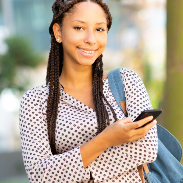 A female high school student on an HBCU campus with her bookbag as she scrolls on her phone, college credit, high school students, pre-college summer programs, social activities, high schoolers, high school juniors, residential program, black colleges, academic programs, united states, summer programs for high school students, HBCUs