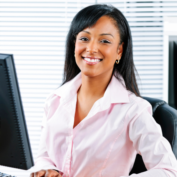 A female college student is sitting at a desk at her internship program, Summer Internships for College Students