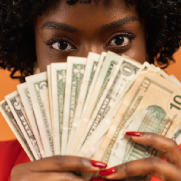 A female college student holding dollar bills over her face, May Minority Scholarships, high school seniors, financial need, african american students, united states, black students, higher education, high school students, hbcus, hcaus