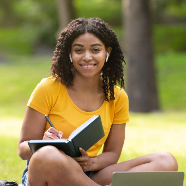 High school student sitting outside applying for July scholarships, high school seniors, high school students, undergraduate students, financial need, positive influence, community involvement, community impact. summer scholarships, scholarships with July deadlines