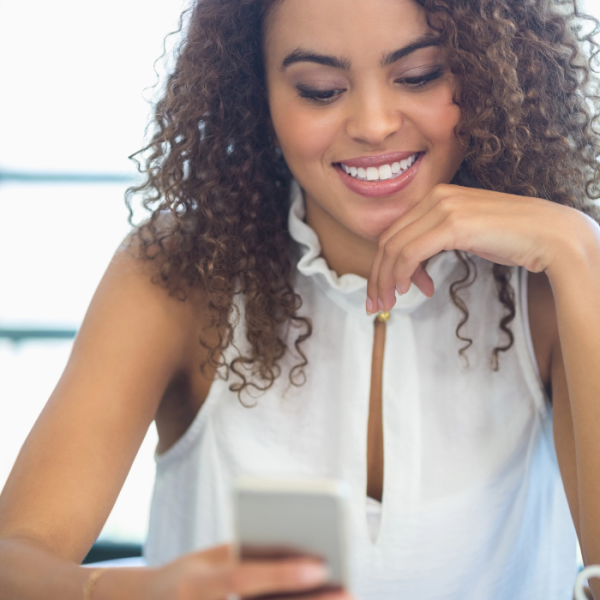 A current college student using her phone to find June Scholarships with No GPA Requirement